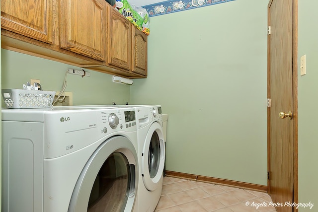 laundry room with cabinets, washing machine and dryer, and light tile patterned floors