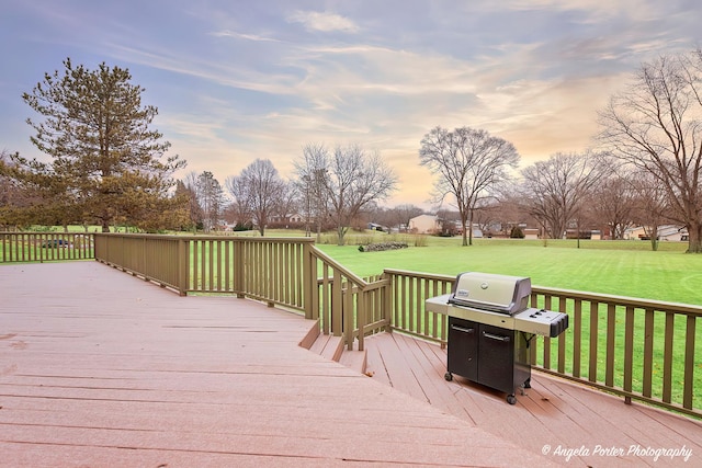 deck at dusk featuring area for grilling and a yard