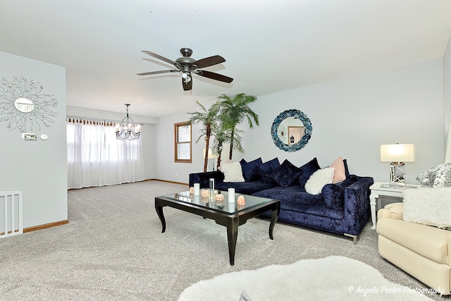 carpeted living room featuring ceiling fan with notable chandelier