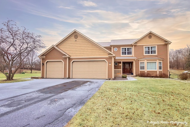 front of property with a garage and a lawn