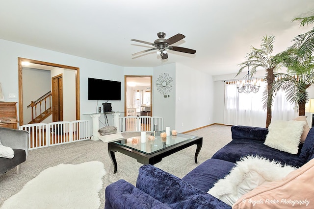 living room featuring ceiling fan with notable chandelier and carpet flooring