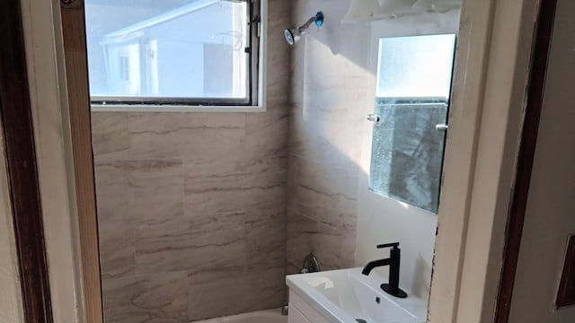 bathroom with vanity and tiled shower / bath