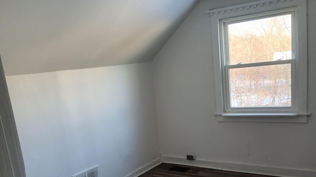 bonus room with dark wood-type flooring and lofted ceiling