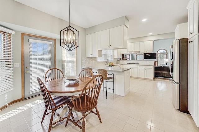 dining room with an inviting chandelier, light tile patterned floors, and a wealth of natural light