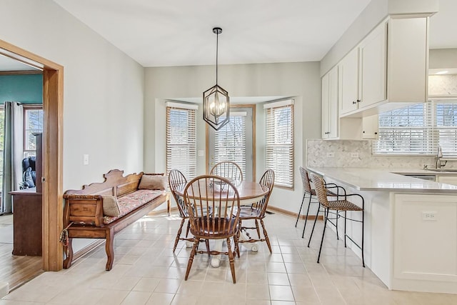 dining room with sink, a wealth of natural light, and an inviting chandelier