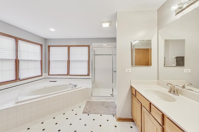 bathroom with vanity and shower with separate bathtub