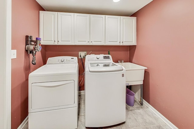 clothes washing area featuring cabinets, sink, independent washer and dryer, and light tile patterned floors