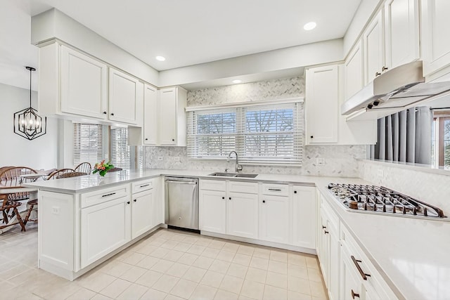 kitchen featuring appliances with stainless steel finishes, sink, white cabinets, hanging light fixtures, and kitchen peninsula