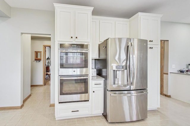 kitchen featuring white cabinetry, appliances with stainless steel finishes, and light tile patterned floors