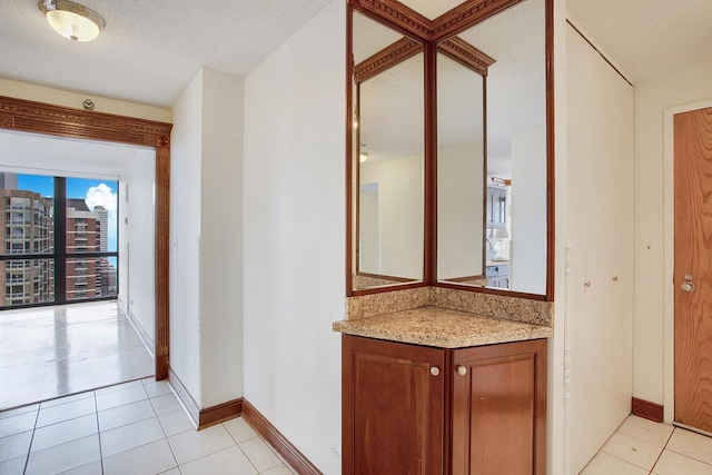 bathroom with tile patterned flooring, vanity, and a textured ceiling