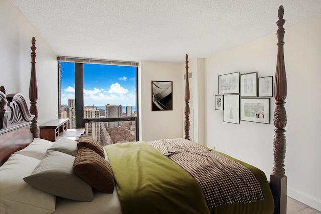 bedroom featuring floor to ceiling windows and a textured ceiling