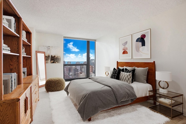 carpeted bedroom with floor to ceiling windows and a textured ceiling