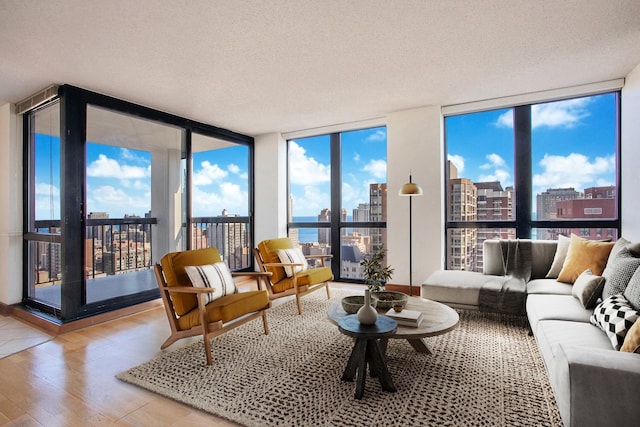 living room featuring hardwood / wood-style flooring, plenty of natural light, and a wall of windows