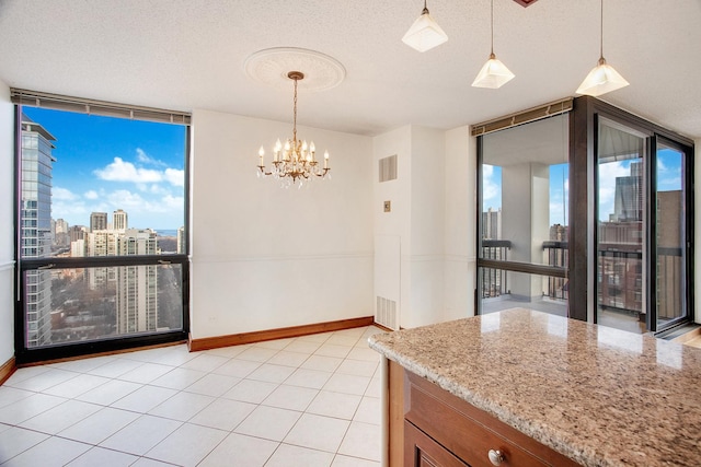 dining room featuring an inviting chandelier, light tile patterned floors, a wall of windows, and a textured ceiling