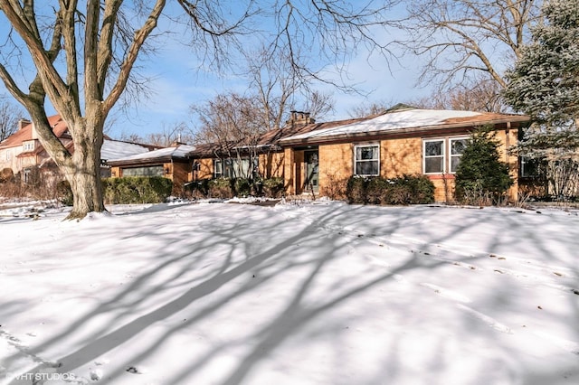 view of front of home with a chimney and brick siding