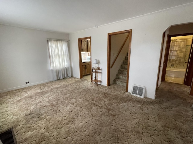 unfurnished bedroom featuring ensuite bathroom and carpet flooring