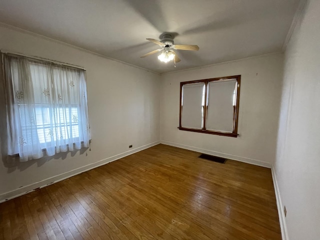 empty room featuring crown molding, dark hardwood / wood-style floors, and ceiling fan