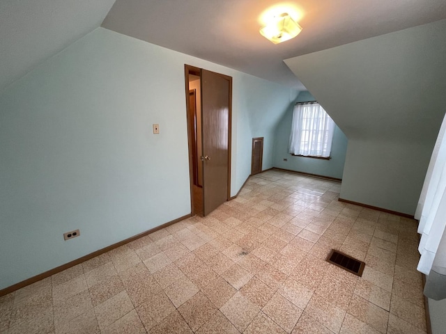 additional living space featuring lofted ceiling