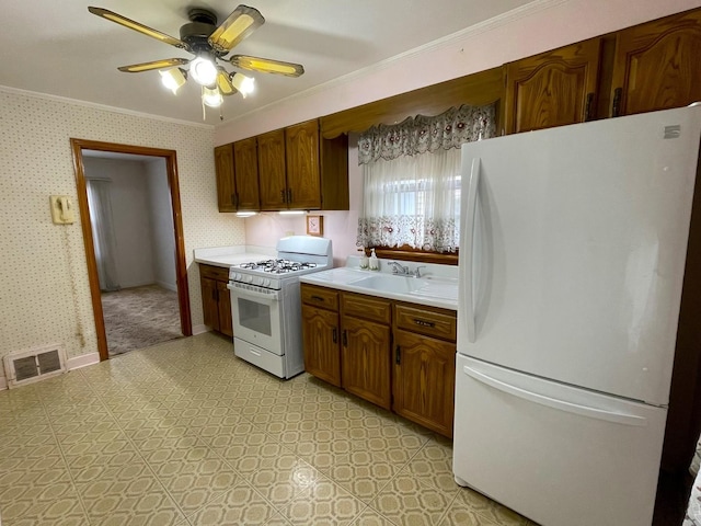 kitchen featuring crown molding, white appliances, ceiling fan, and sink