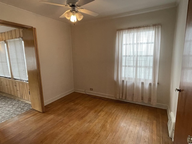 spare room featuring ceiling fan, ornamental molding, and wood-type flooring