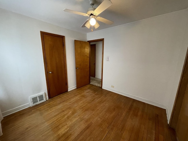 unfurnished bedroom with ceiling fan and hardwood / wood-style floors