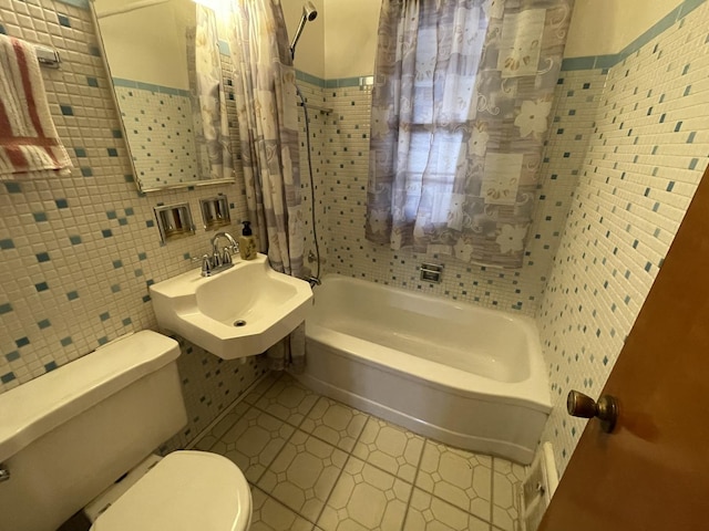 full bathroom with tile walls, sink, tiled shower / bath combo, and toilet