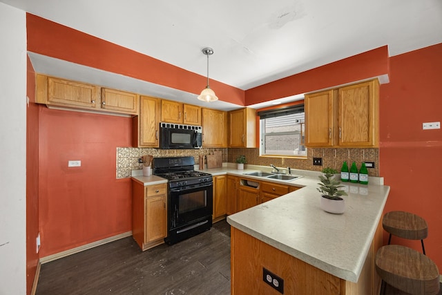 kitchen featuring pendant lighting, tasteful backsplash, sink, kitchen peninsula, and black gas range