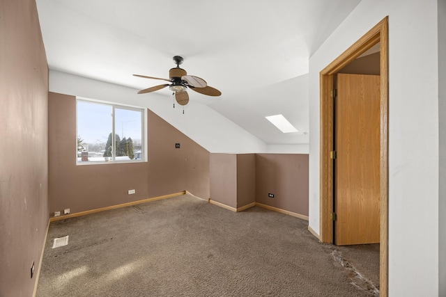 additional living space featuring ceiling fan, vaulted ceiling with skylight, and carpet