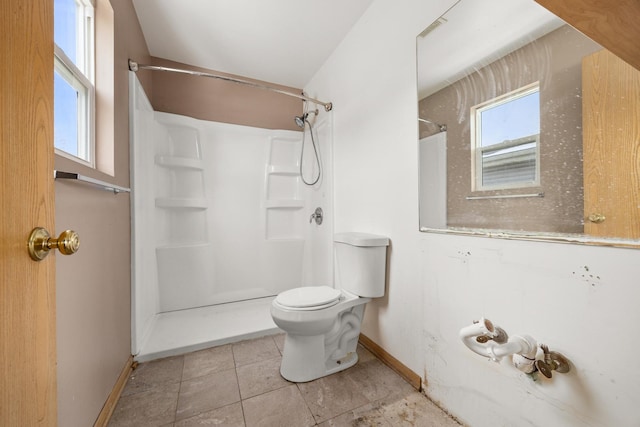 bathroom with a shower, tile patterned floors, and toilet