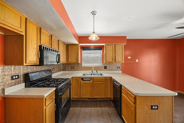 kitchen with dark hardwood / wood-style floors, sink, hanging light fixtures, and black appliances