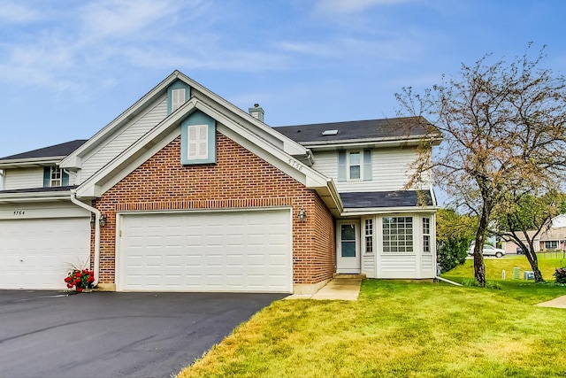 view of property with a garage and a front lawn