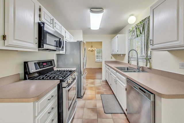 kitchen with white cabinetry, appliances with stainless steel finishes, sink, and light tile patterned floors