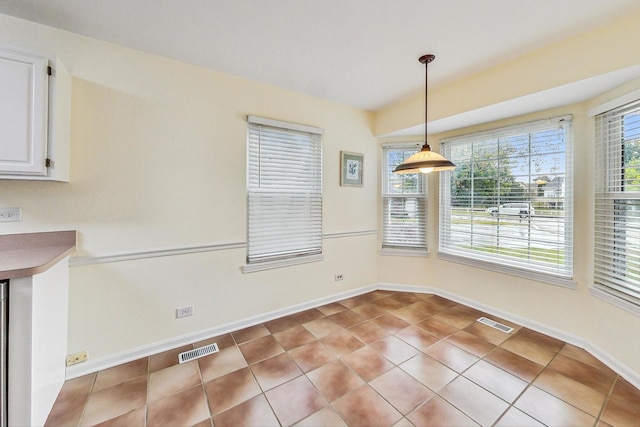 unfurnished dining area with a wealth of natural light and light tile patterned flooring