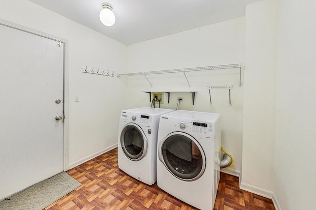 washroom with parquet flooring and washing machine and clothes dryer