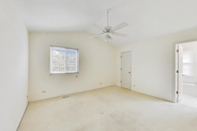 unfurnished room with vaulted ceiling, light colored carpet, and ceiling fan