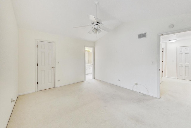 carpeted empty room featuring ceiling fan and vaulted ceiling