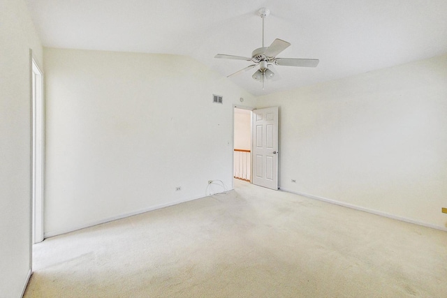 spare room featuring vaulted ceiling, light carpet, and ceiling fan