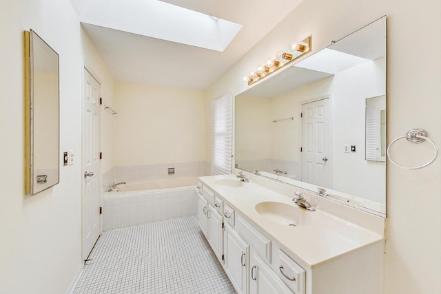 bathroom featuring vanity, a relaxing tiled tub, a skylight, and tile patterned floors