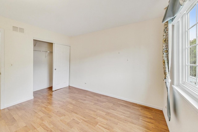 unfurnished bedroom featuring light hardwood / wood-style flooring and a closet