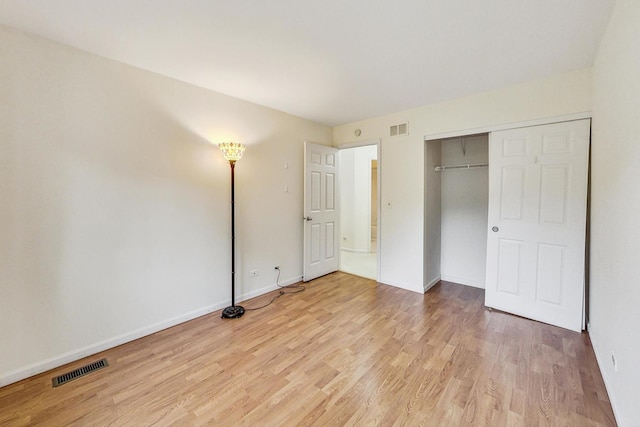 unfurnished bedroom featuring a closet and light wood-type flooring