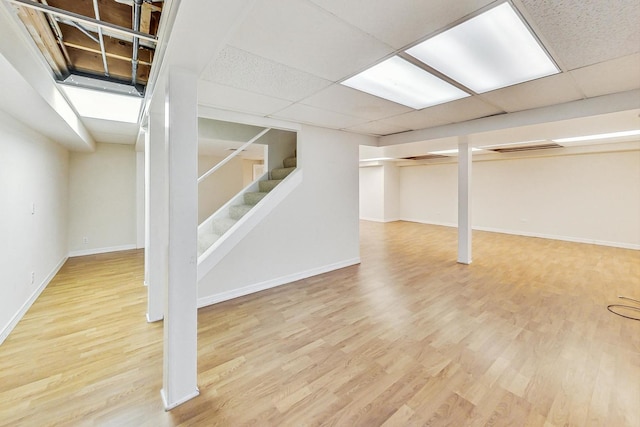 basement with wood-type flooring and a drop ceiling