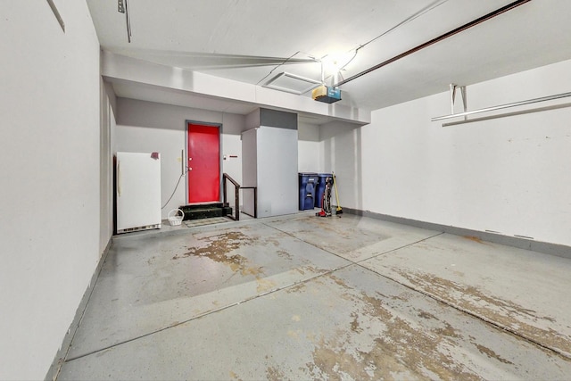 garage with a garage door opener and white fridge