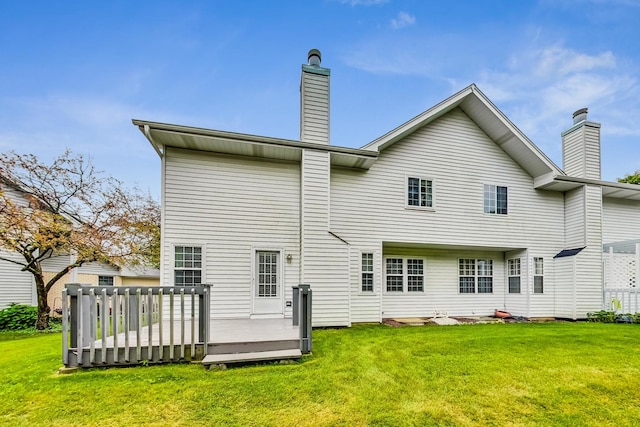 rear view of house featuring a wooden deck and a yard