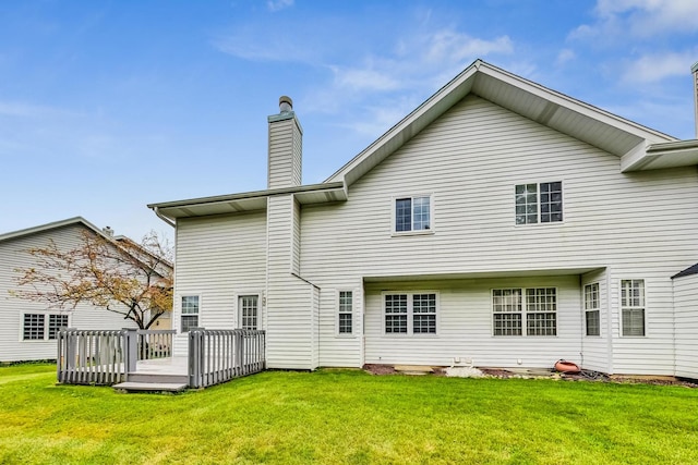 back of house with a wooden deck and a lawn