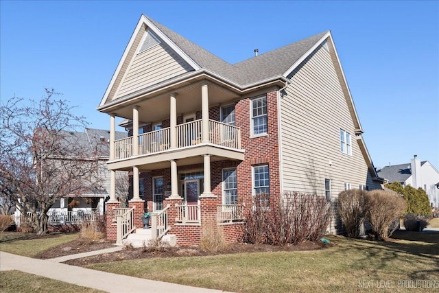 view of front of property with a balcony, a front yard, and covered porch