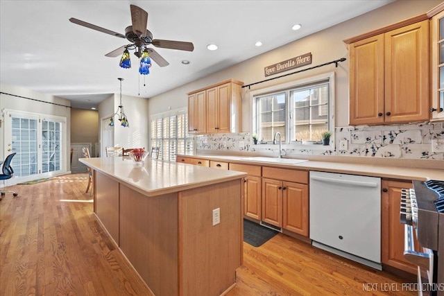 kitchen featuring sink, light hardwood / wood-style flooring, dishwasher, hanging light fixtures, and a kitchen island