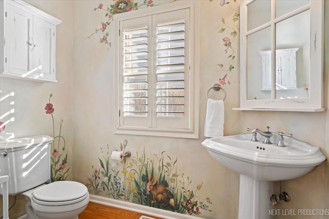 bathroom with toilet, hardwood / wood-style floors, and a wealth of natural light