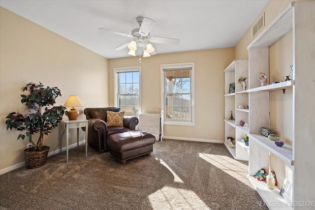 living area with ceiling fan and carpet