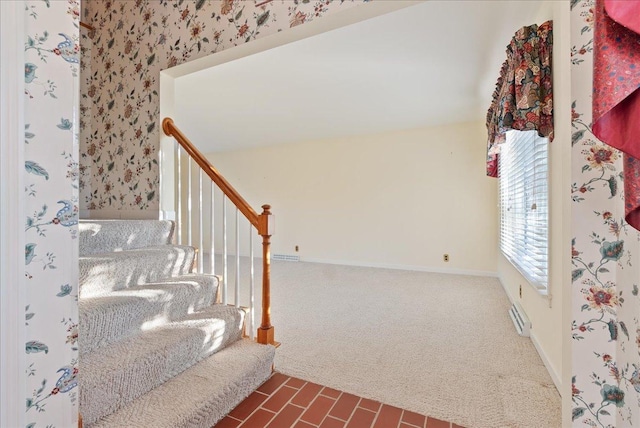 stairs featuring baseboard heating and carpet floors