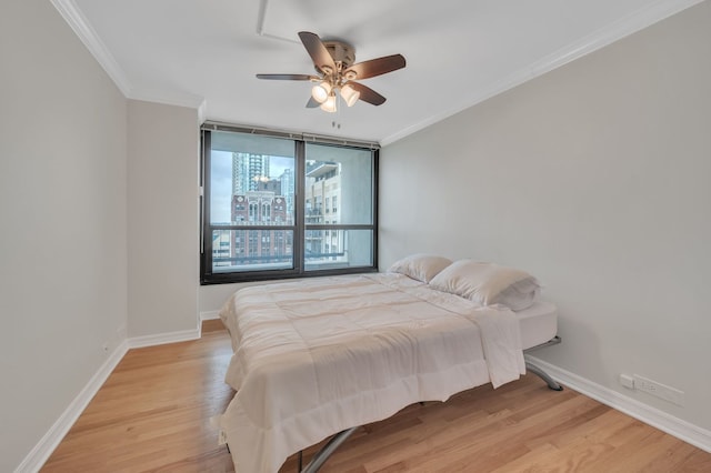 bedroom with ceiling fan, ornamental molding, and light hardwood / wood-style flooring